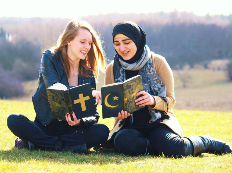 Een christelijke en islamitische vriendin lezen de Bijbel en de Koran